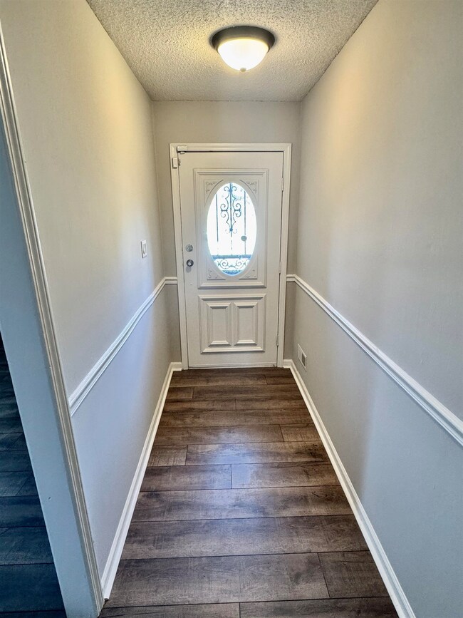 Doorway with dark hardwood / wood-style flooring a