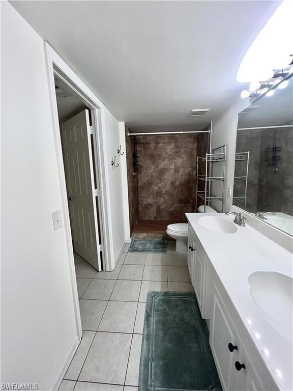 Full bathroom featuring a tile shower, double vanity, and tile patterned floors