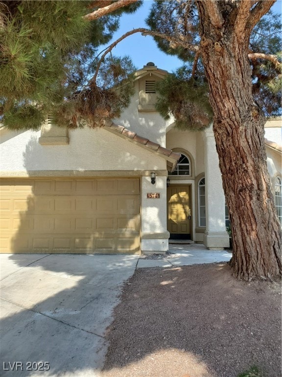 View of front facade with stucco siding, driveway,