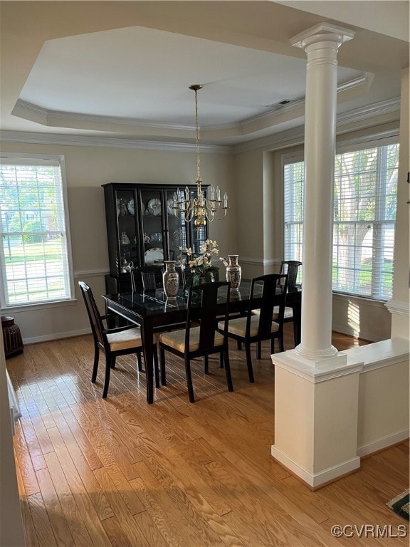 Dining area featuring ornate columns, a raised cei