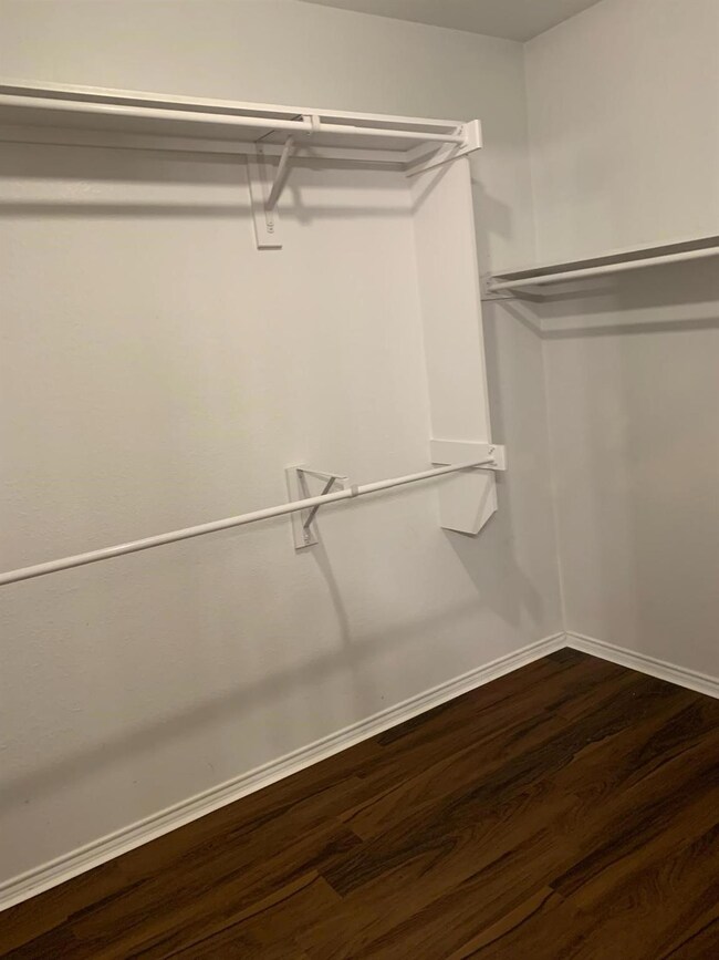 Walk in closet featuring dark hardwood / wood-styl