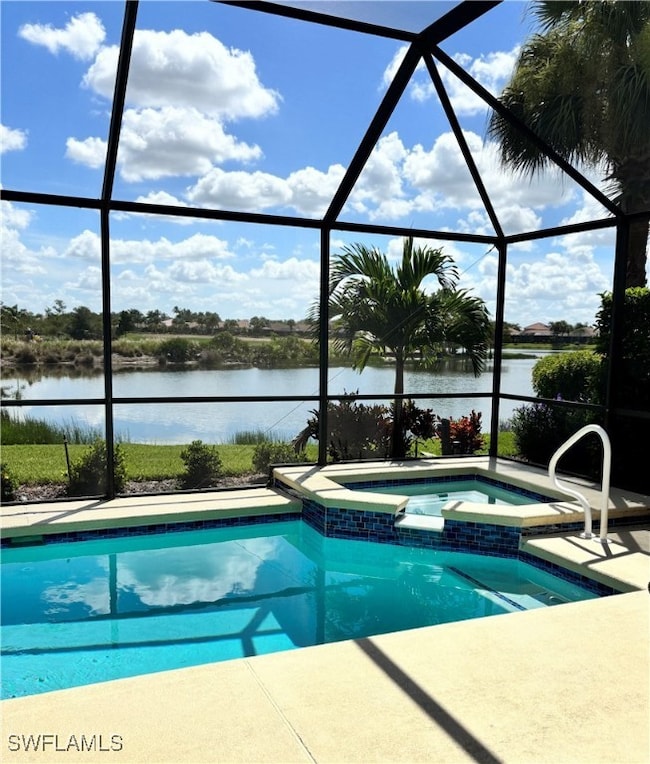 View of swimming pool with a water view, a pool with connected hot tub, a lanai, and a patio area