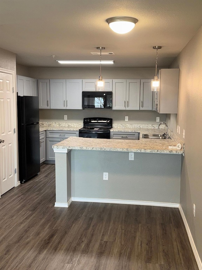 Kitchen featuring light stone counters, a sink, fr