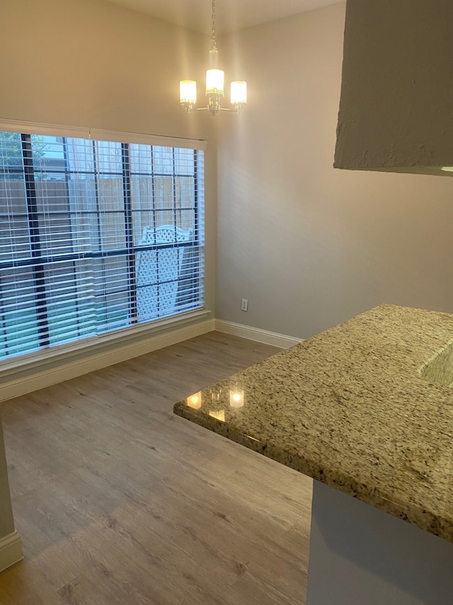 Unfurnished dining area featuring light wood finished floors and a chandelier