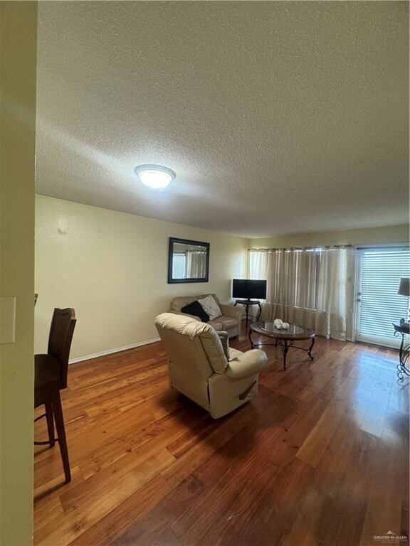 Carpeted living room with a textured ceiling and crown molding