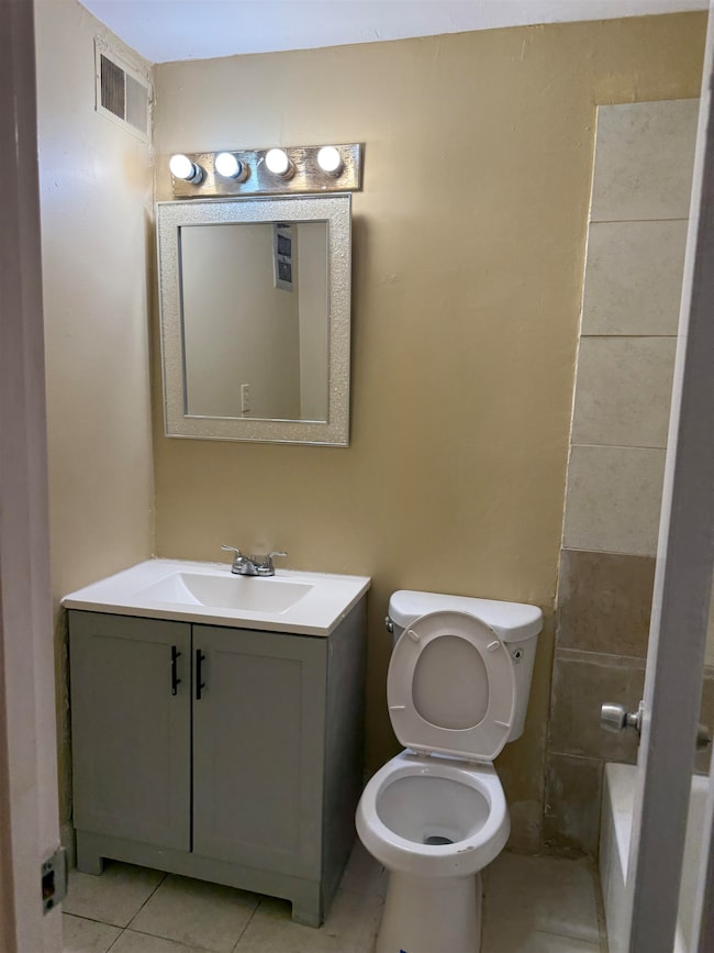Bathroom featuring vanity, a tub to relax in, and tile patterned floors