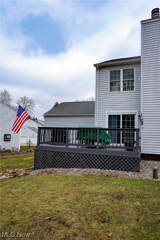 Rear view of house featuring a yard and a deck