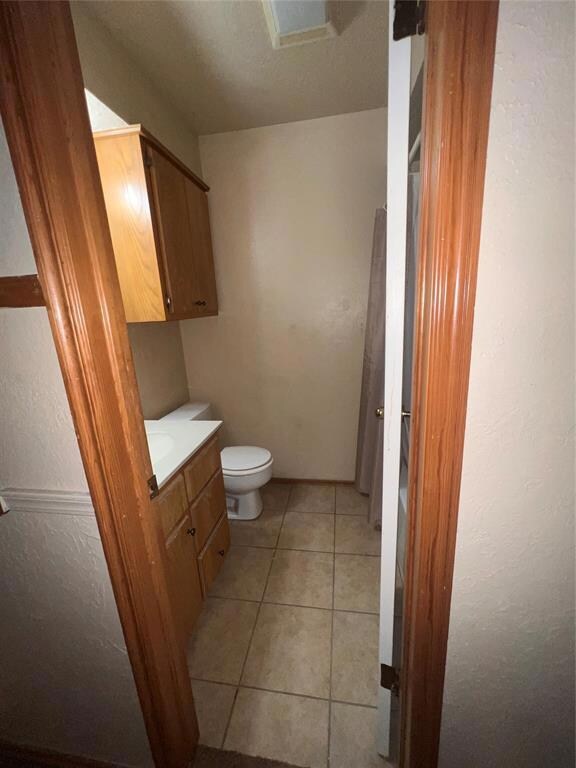 Bathroom with tile patterned floors, vanity, and t