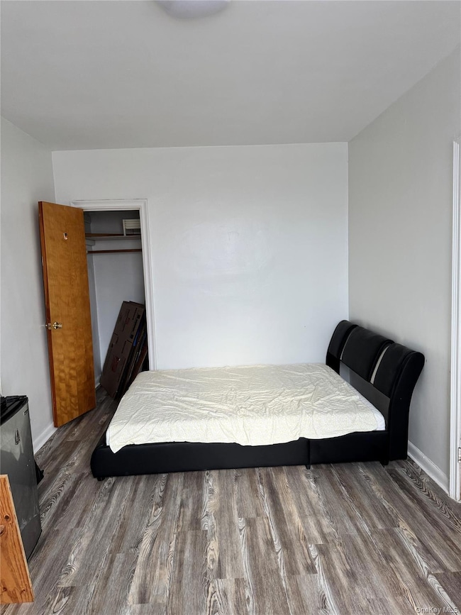 Bedroom featuring wood finished floors and baseboards