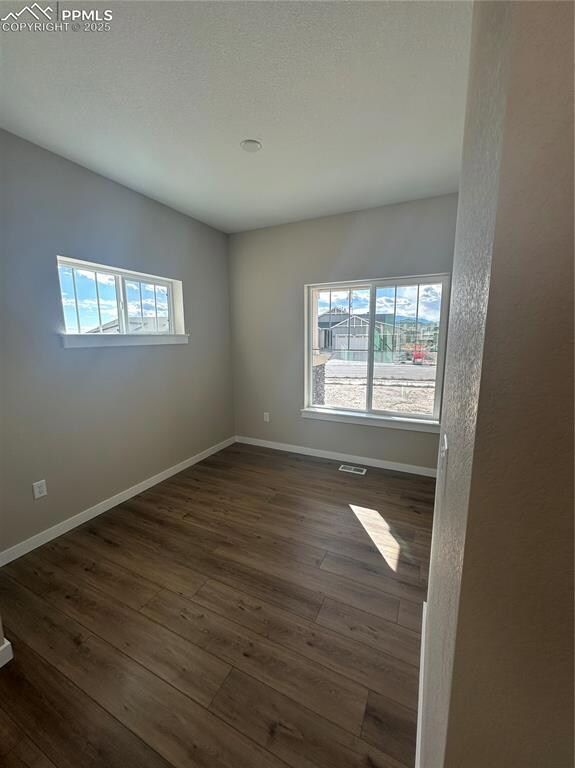 Empty room featuring dark wood-type flooring