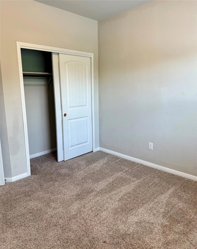 Unfurnished bedroom with carpet floors and a clos