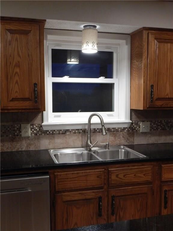 New stainless sink backed by lovely backsplash.  L