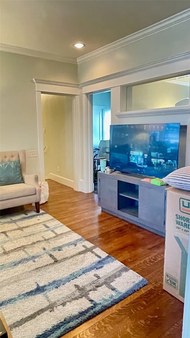 View of living room into hall way and secondary bedroom featuring a faux fireplace and mirrored mantle.