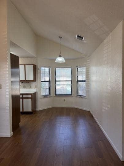 Unfurnished dining area featuring vaulted ceiling