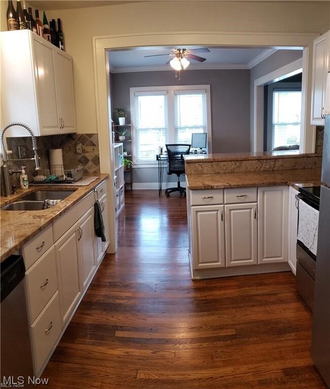 Kitchen featuring dark hardwood / wood-style floors, appliances with stainless steel finishes, ceiling fan, and white cabinetry