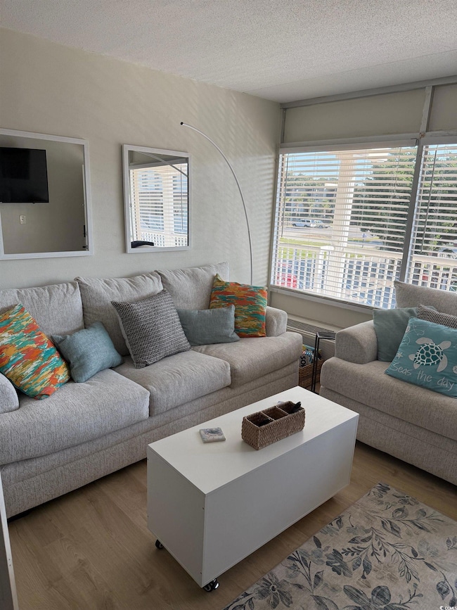 Living area with wood finished floors and a textured ceiling