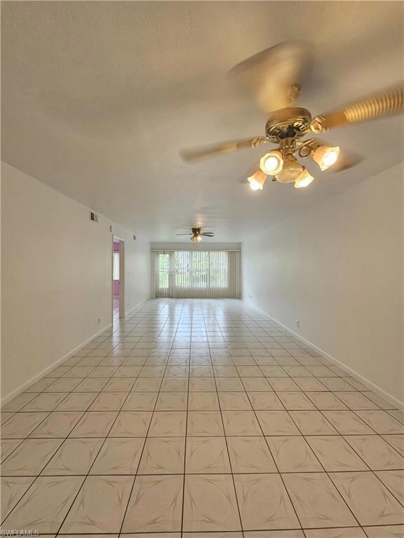 Spare room with ceiling fan and light tile patterned floors