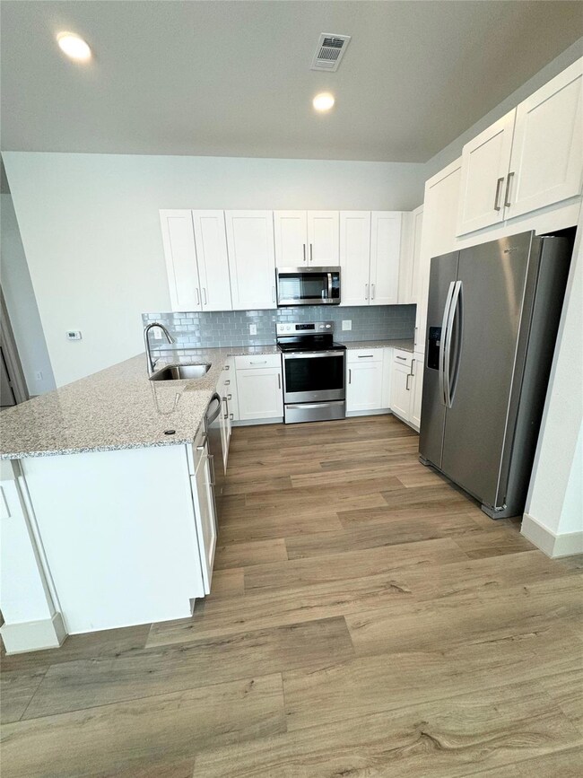 Kitchen featuring backsplash, light stone counters