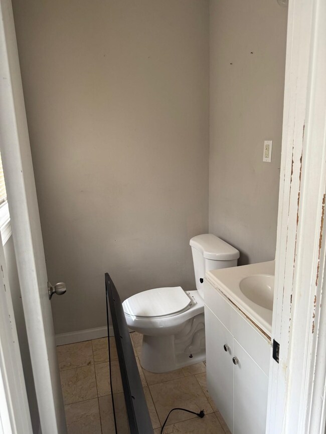 Half bath featuring tile patterned floors, toilet,