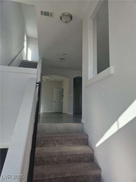 Stairway with visible vents, arched walkways, and