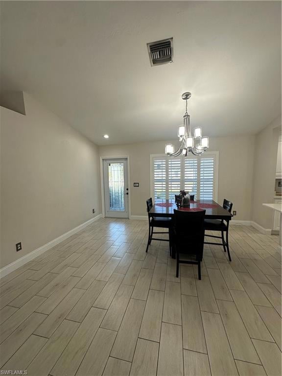 Dining space featuring an inviting chandelier and light wood-type flooring