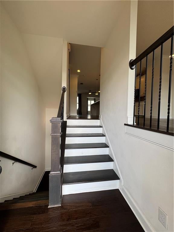 Staircase featuring wood finished floors and recessed lighting