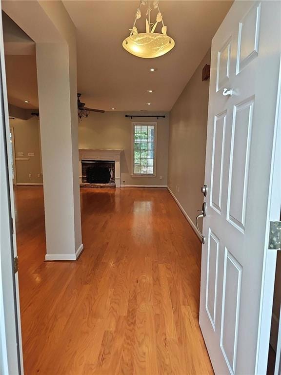 Hall with baseboards and light wood-style floors