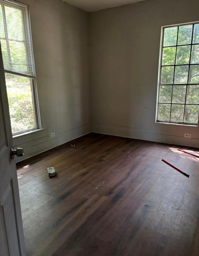 Unfurnished room with baseboards and dark wood fin