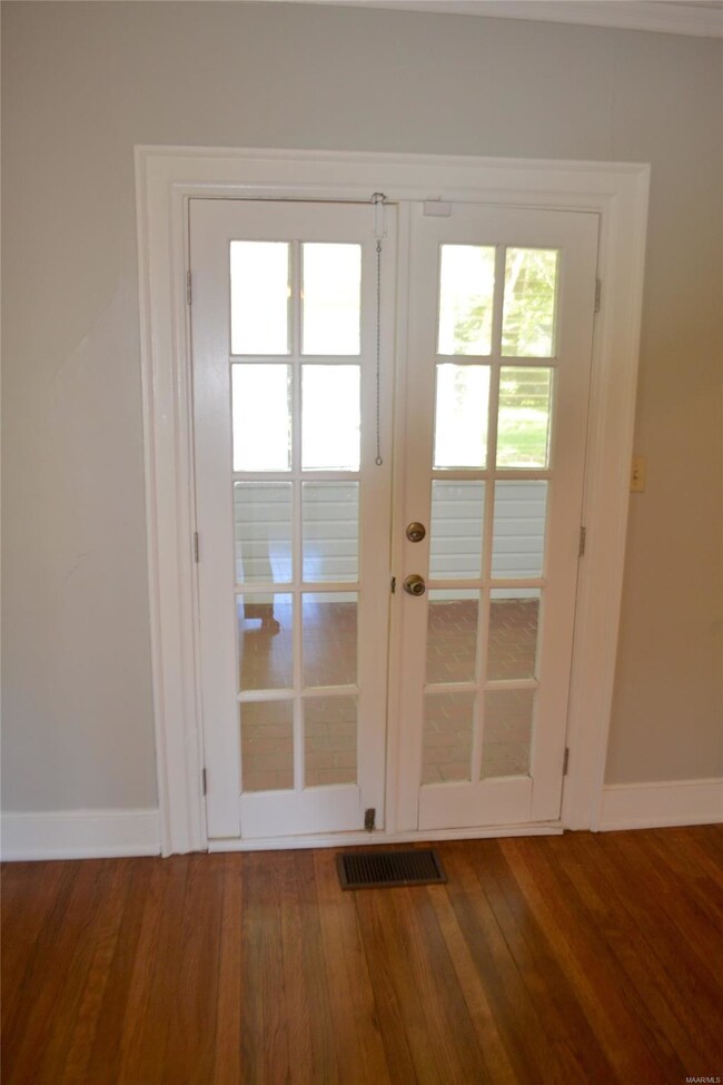 French doors lead into the sunroom off of the livi