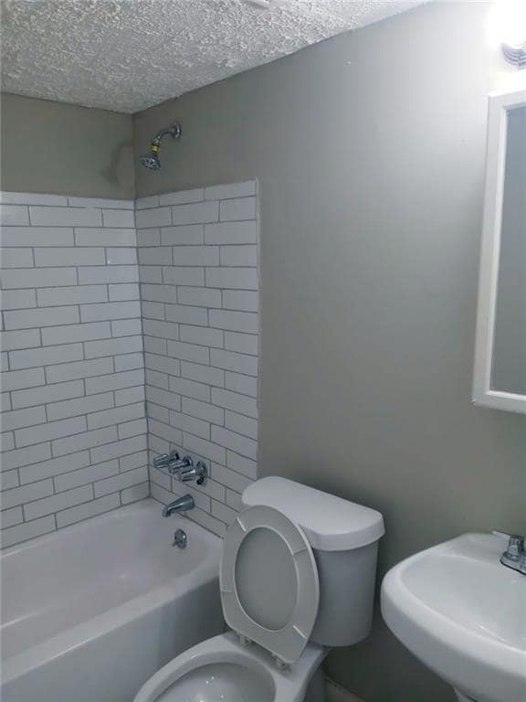 Full bathroom with toilet, tiled shower / bath com