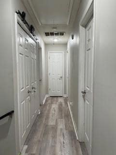 Hallway featuring wood finished floors and attic access