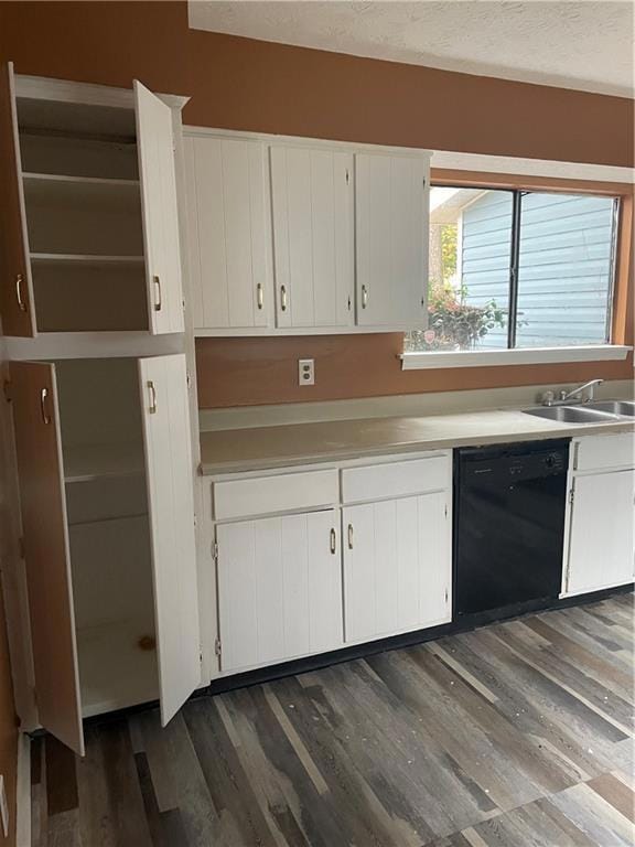 Kitchen with dishwasher, white cabinetry, dark har