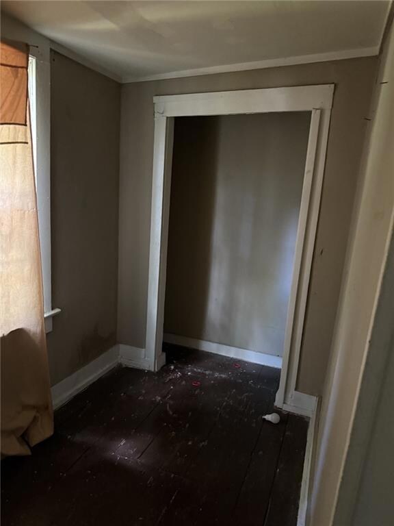 Unfurnished bedroom with crown molding and baseboards