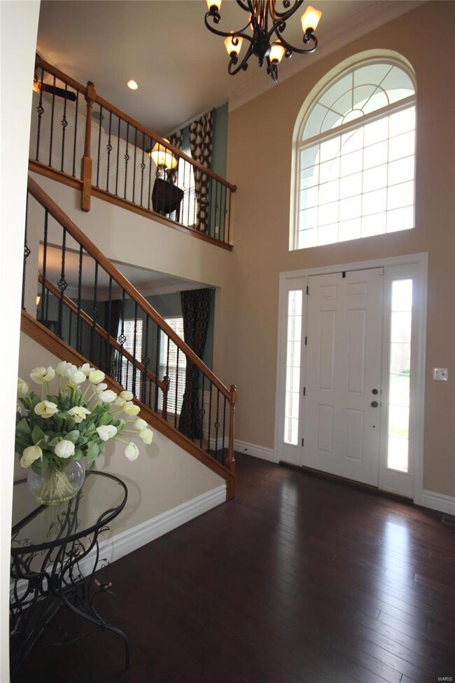 Two story foyer, staircase with wrought iron spind