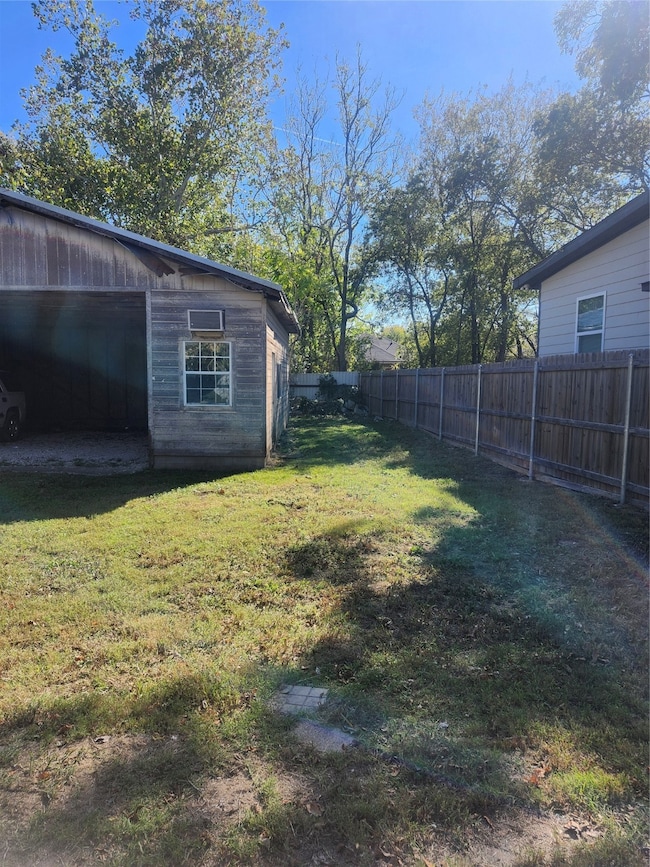 Fenced backyard featuring an outdoor structure