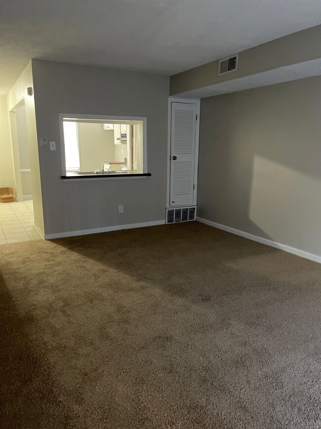 Empty room with carpet flooring and baseboards