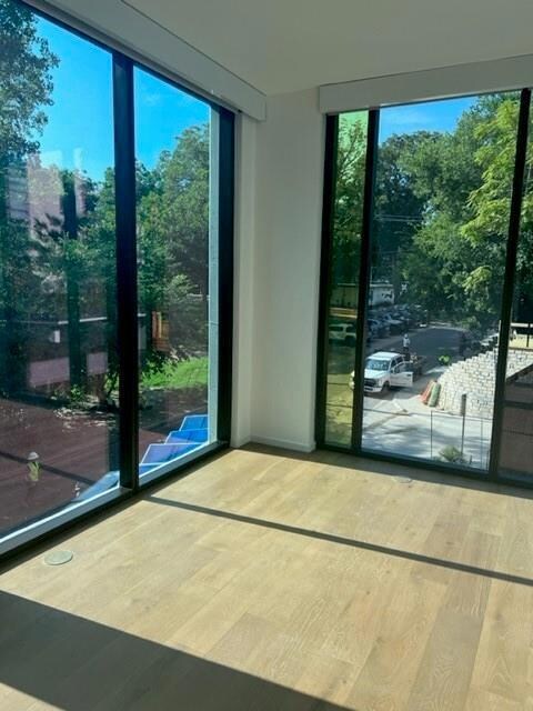 Doorway featuring a wall of windows and wood fini
