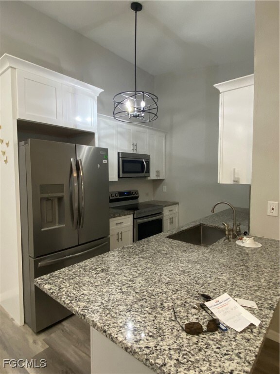 Kitchen with refrigerator, stove, light wood finis