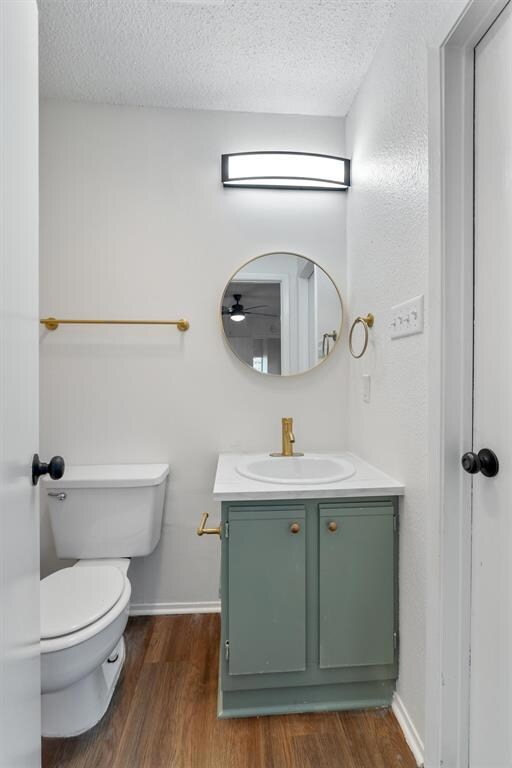 Bathroom featuring vanity, toilet, wood finished 