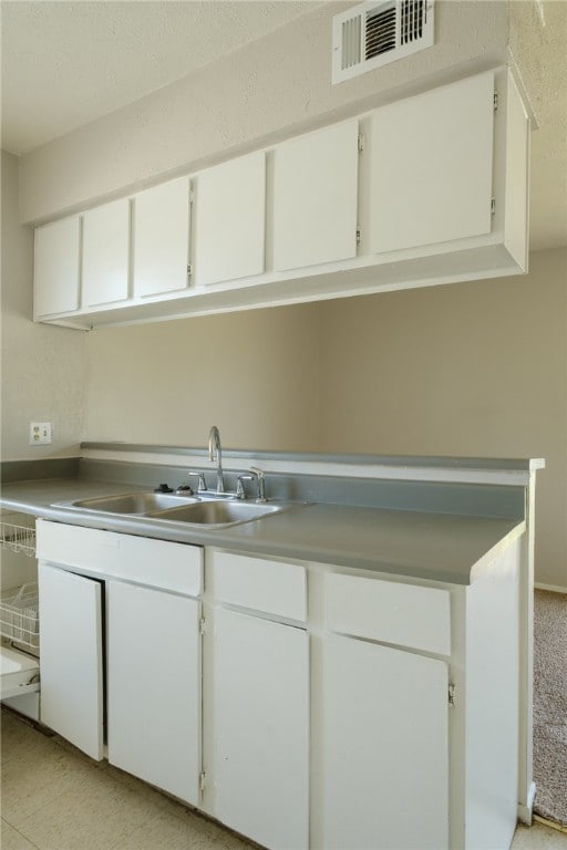Kitchen with white cabinetry, visible vents, and a