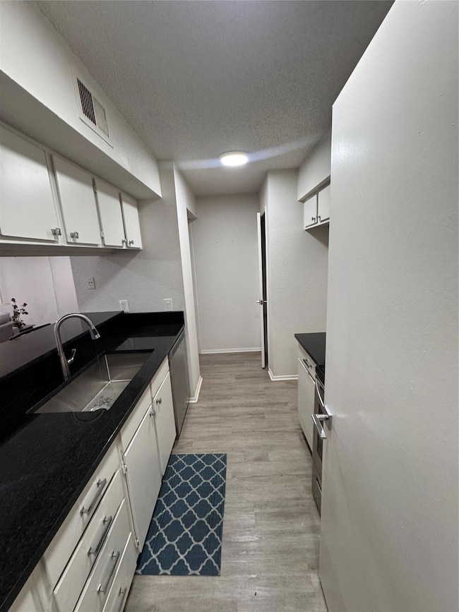 Kitchen featuring white cabinets, visible vents, d