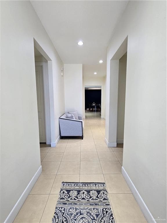 Hall with light tile patterned floors and recessed lighting