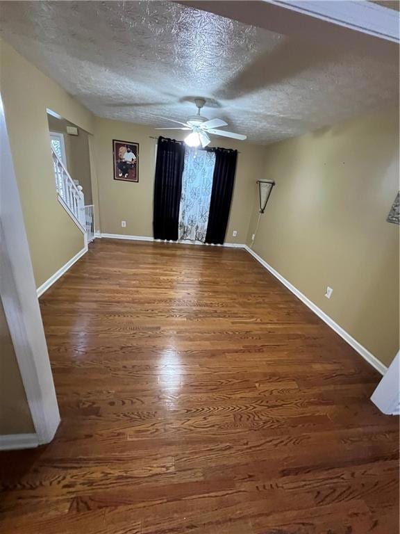Empty room featuring a textured ceiling, wood fini