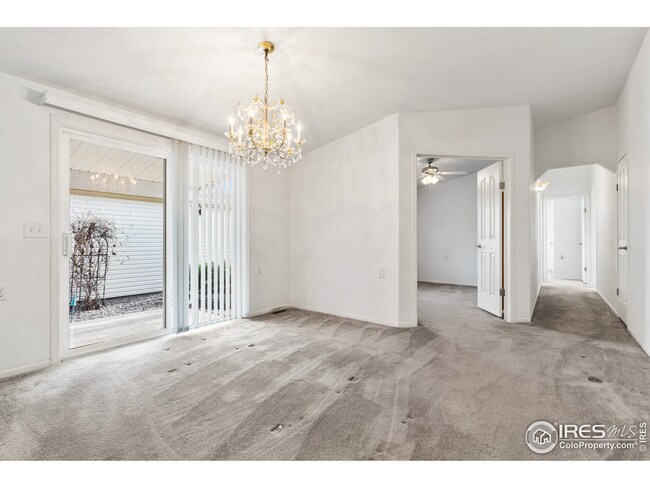 Open formal dining area with enticing chandelier next to the home office with double doors.