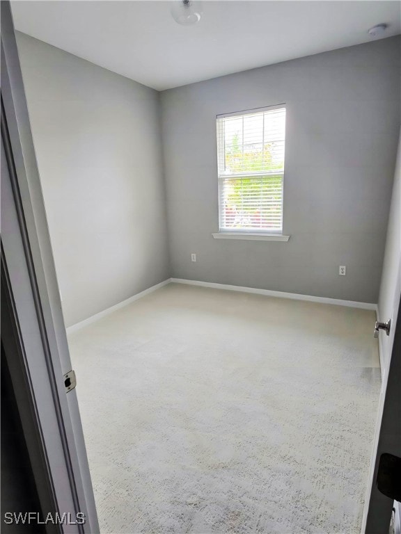 Carpeted spare room with baseboards and a smoke de