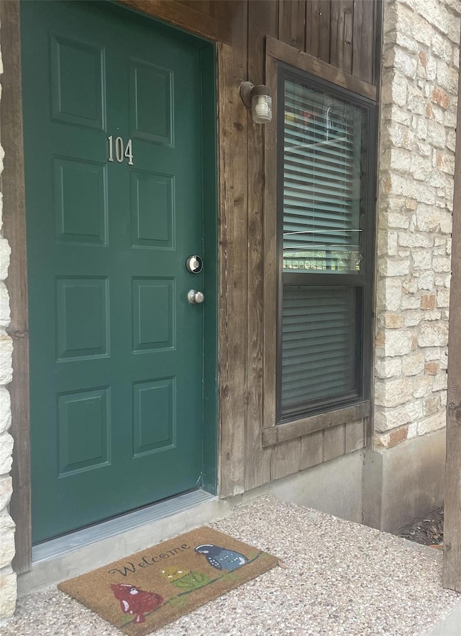 Entrance to property featuring stone siding