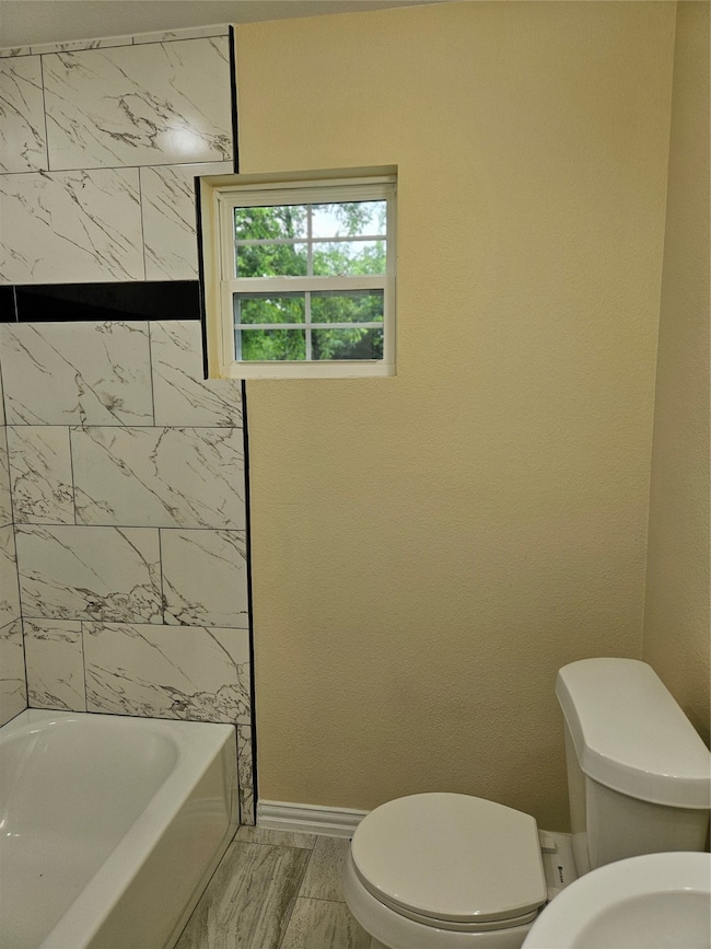Bathroom with toilet and shower / washtub combination