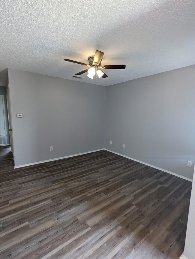 Unfurnished room with dark wood-style floors, a c