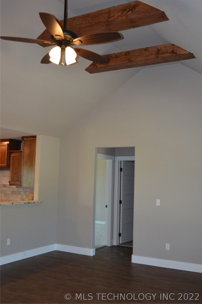 Vaulted ceiling in living room with beams.