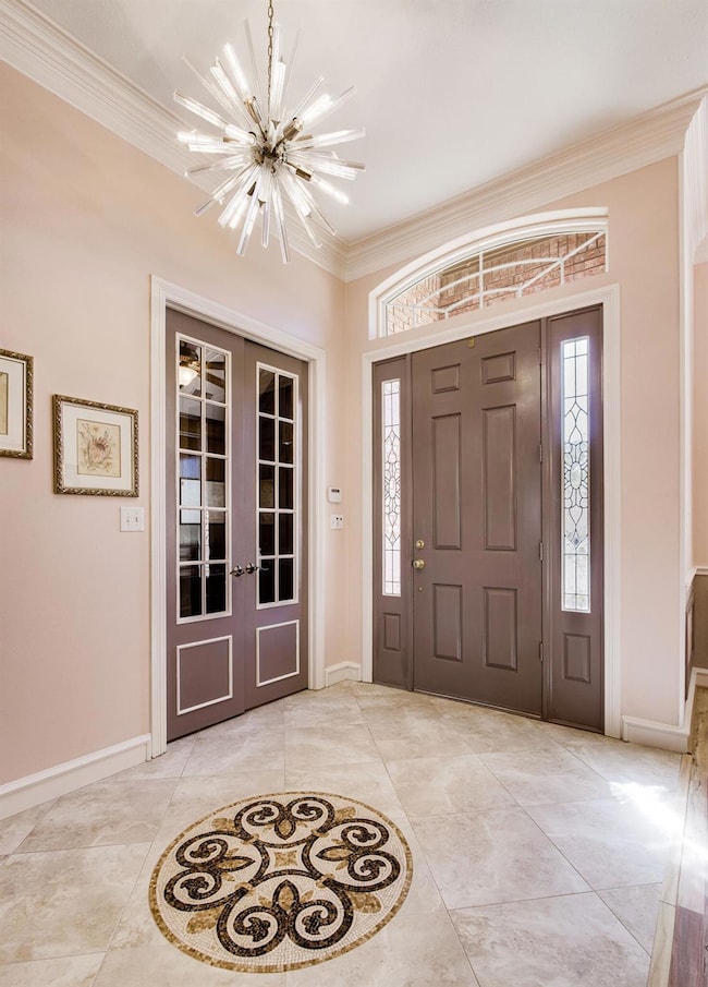 Grand foyer with a sparkling contemporary chandelier and intricate inlayed mosaic tile medallion design